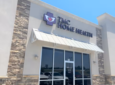 Exterior view of a building entrance with TMC Home Health sign