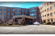 Brick-assisted living building with a covered entrance and a car parked in front.
