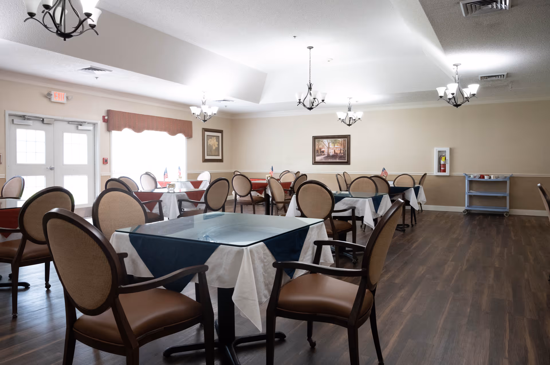 Edenton House dining room with round tables, chairs, and tablecloths arranged for meals.