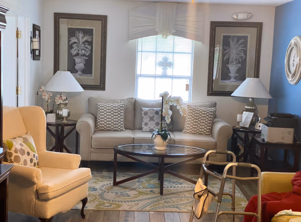 Cozy living room in a senior facility featuring a sofa, chairs, and coffee table.