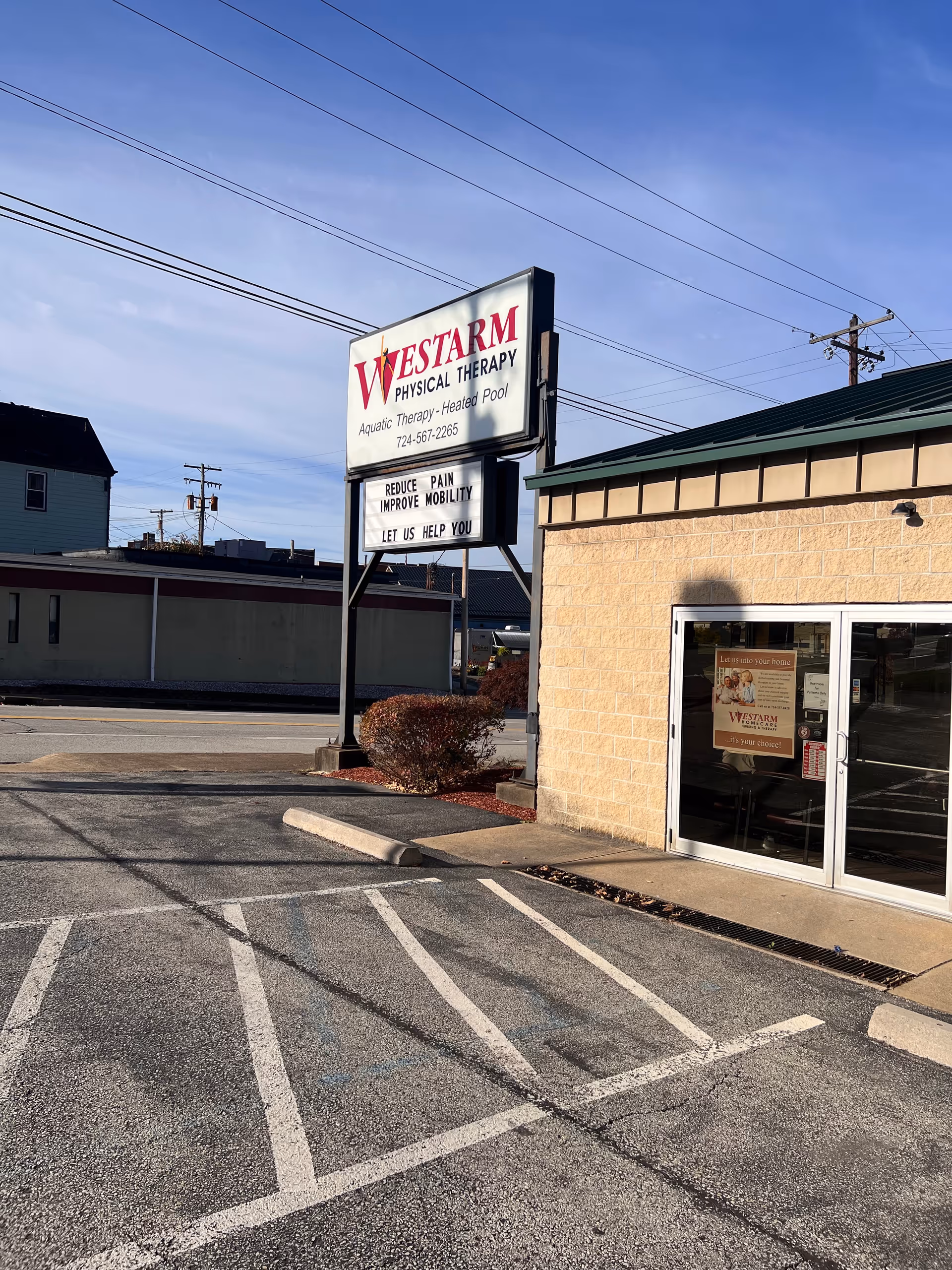 Exterior view of Westarm Physical Therapy sign and entrance with parking lot.
