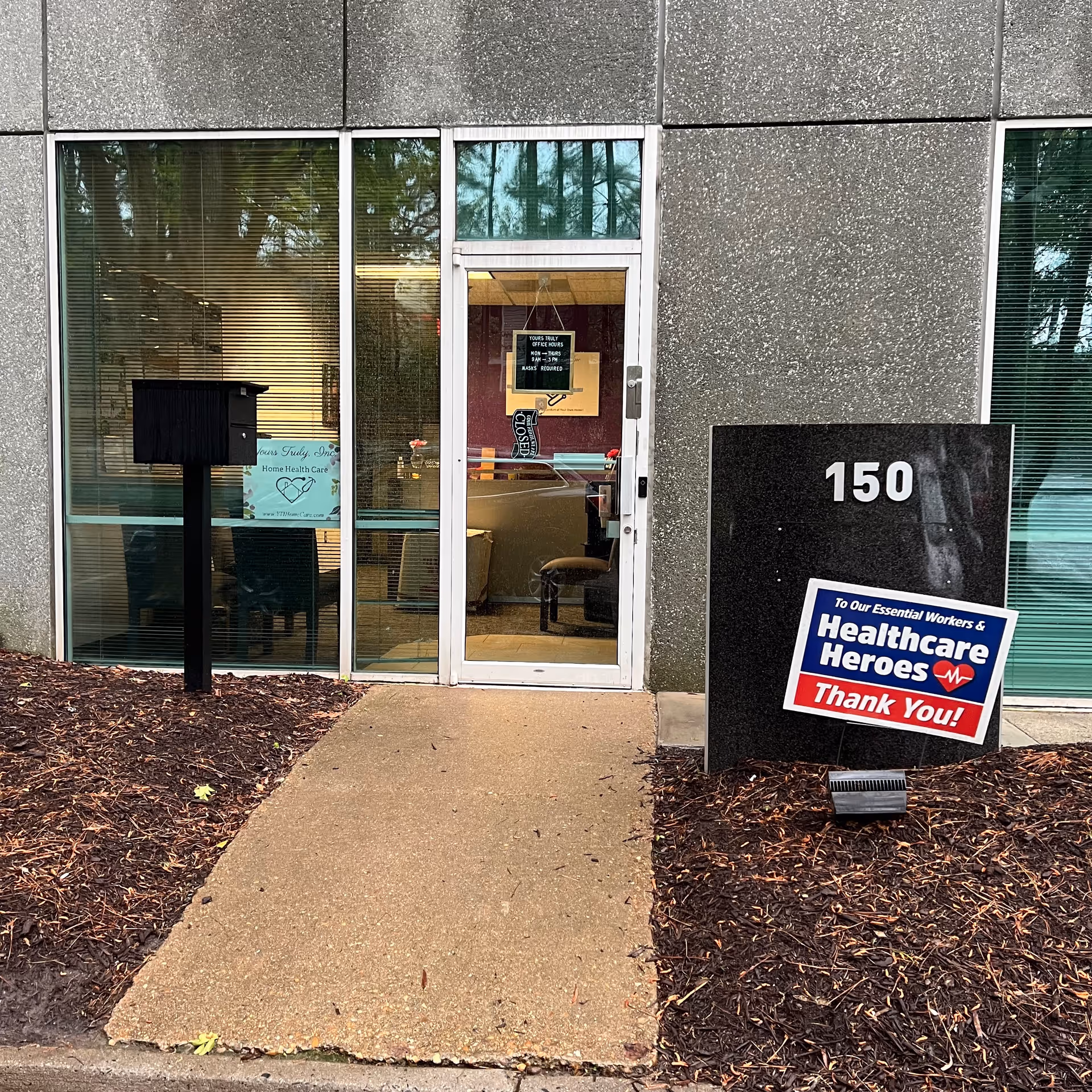 Glass entrance to a building with the number 150 and Healthcare Heroes sign.
