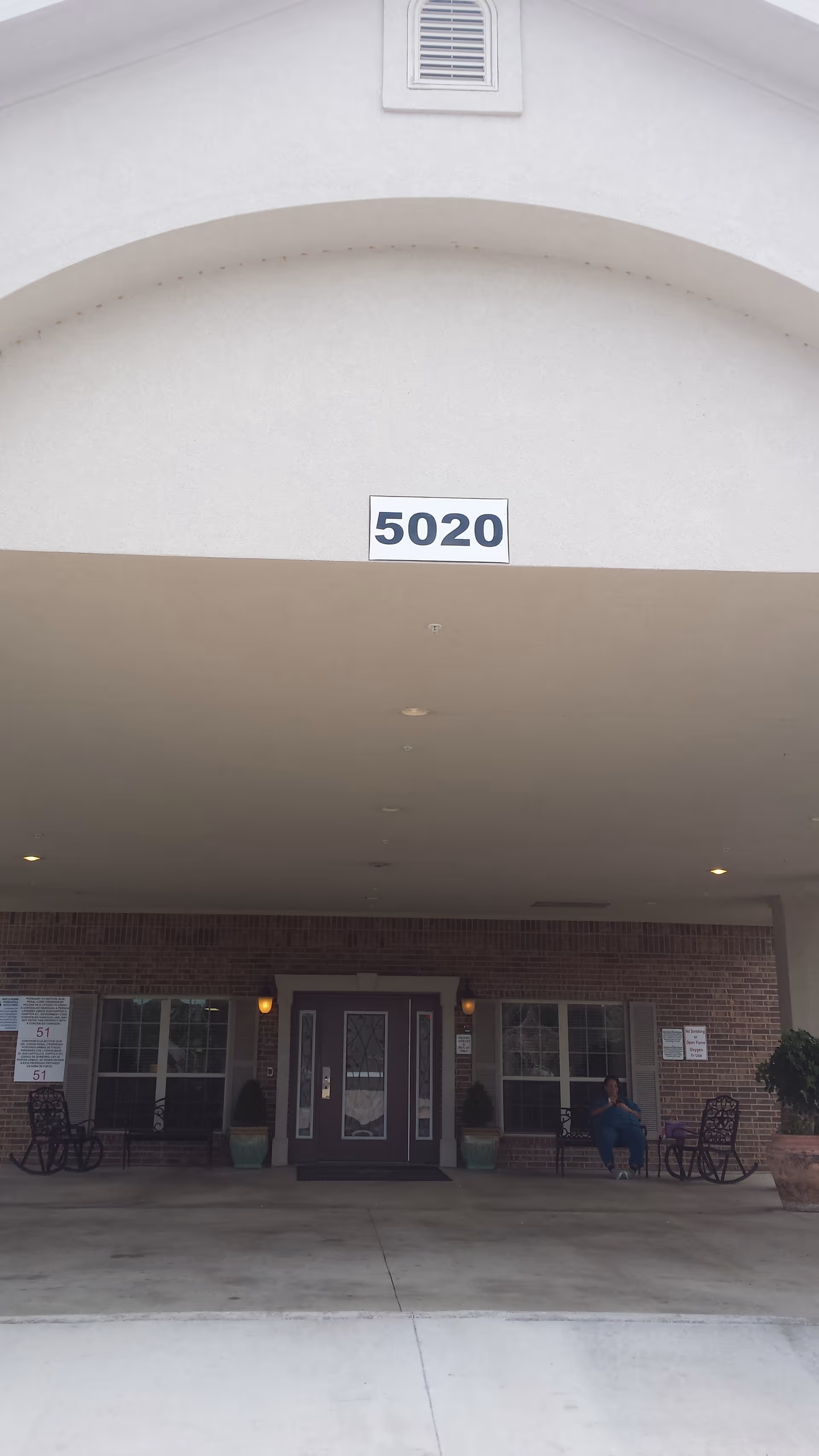 Front entrance of a senior living facility with an arched overhang and 5020.
