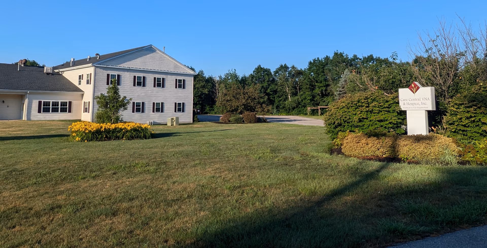 Exterior view of Care Central VNA & Hospice facility with manicured lawn and sign.