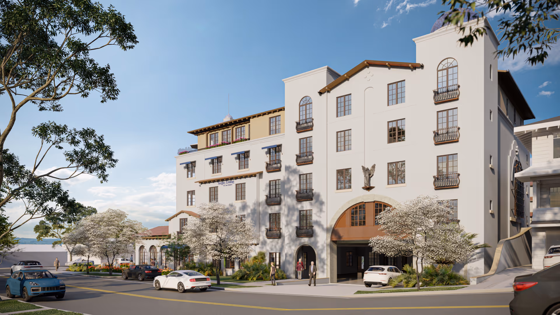 Exterior view of a multi-story senior living facility named Aegis Living San Rafael with white walls, multiple windows with decorative railings, and a tower-like structure on the right. Several cars are parked along the street and people are walking on the sidewalk. Trees with white blossoms line the street under a clear blue sky.