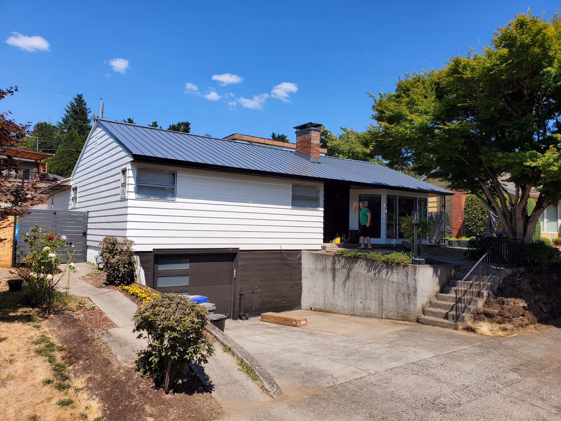 Single-story care home exterior with driveway, steps, and a person near the entrance.