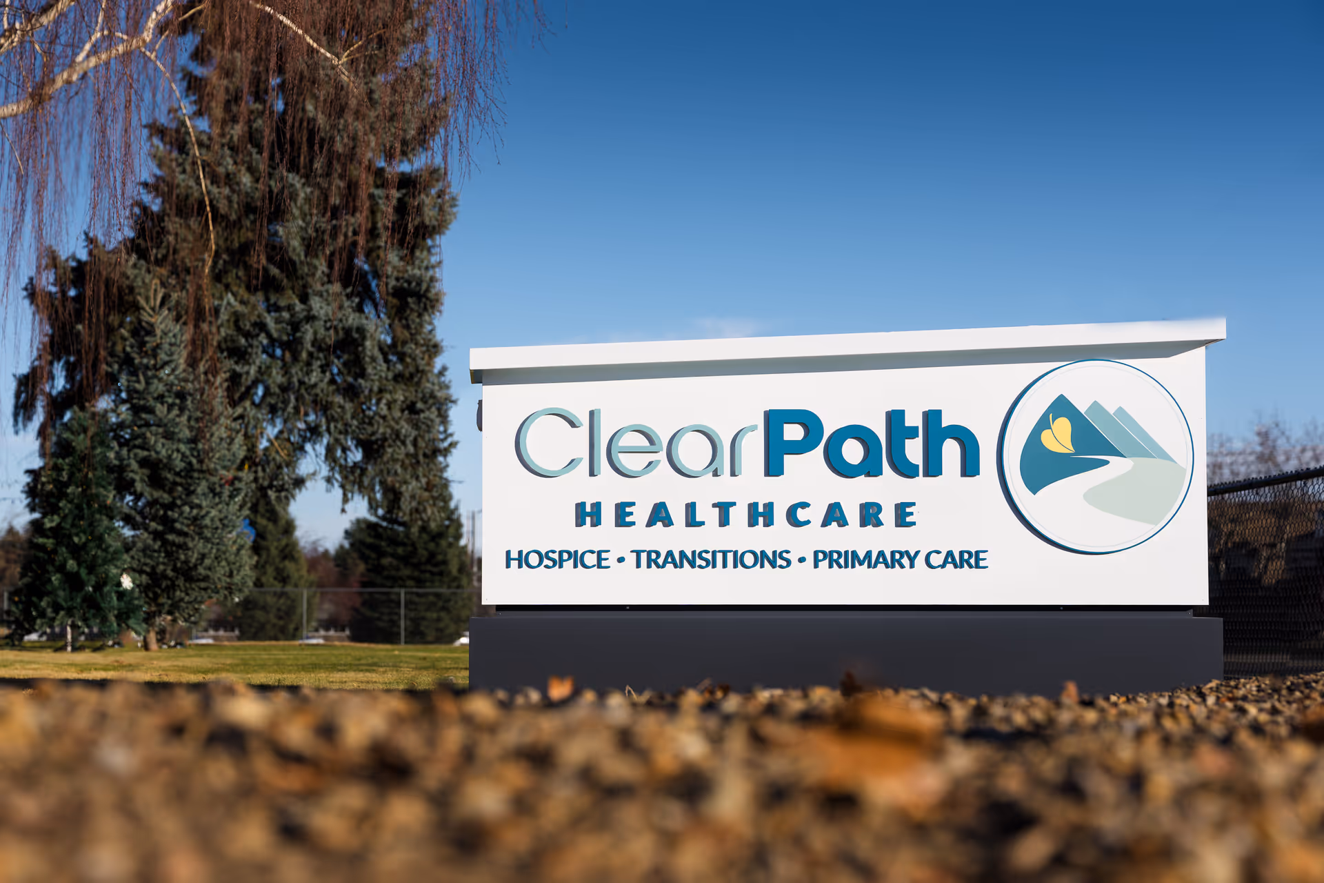 Outdoor sign for ClearPath Healthcare with logo and landscape background.
