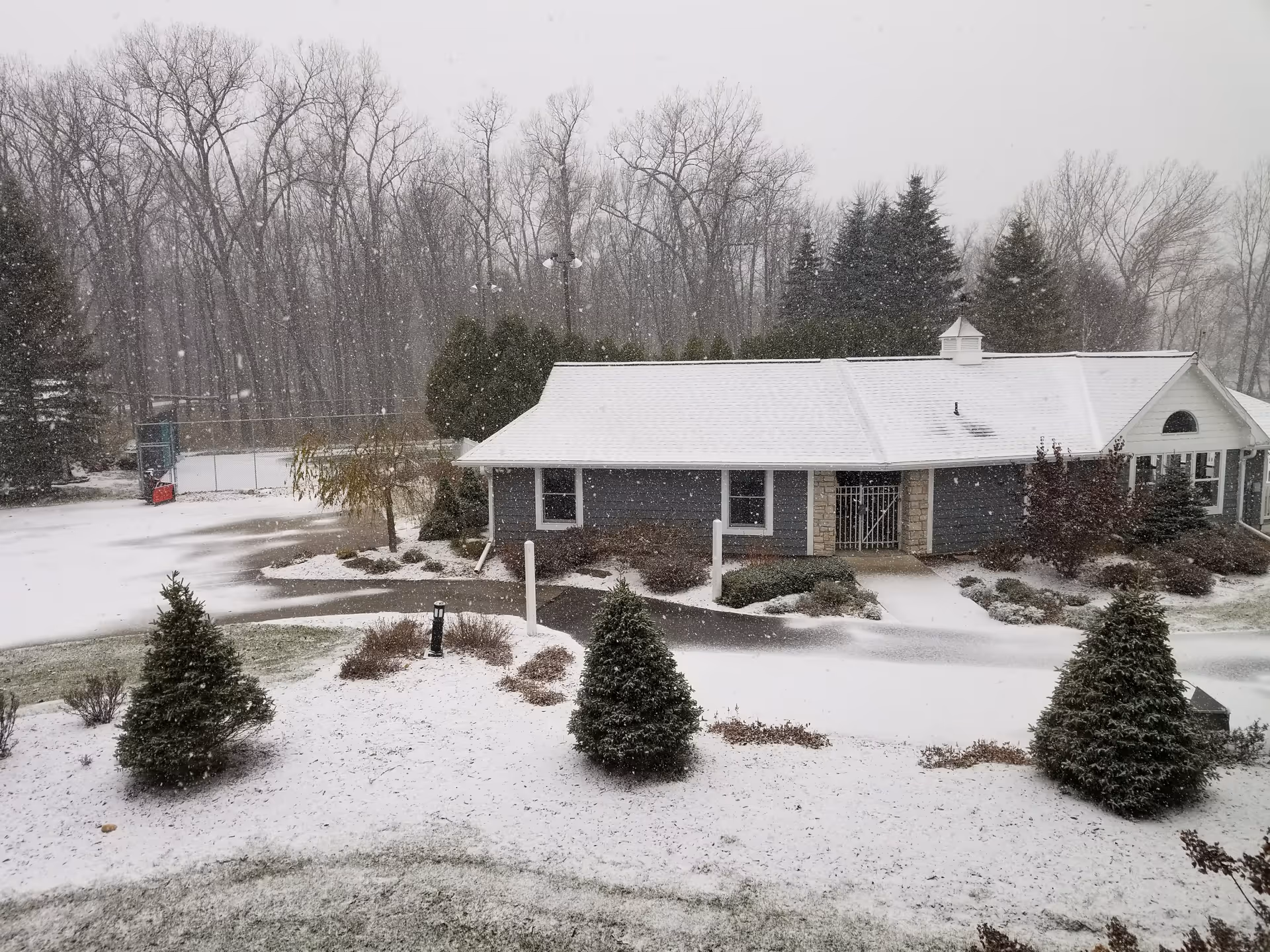 Snowy exterior of Rennes Health & Rehab Center De Pere, front entrance visible