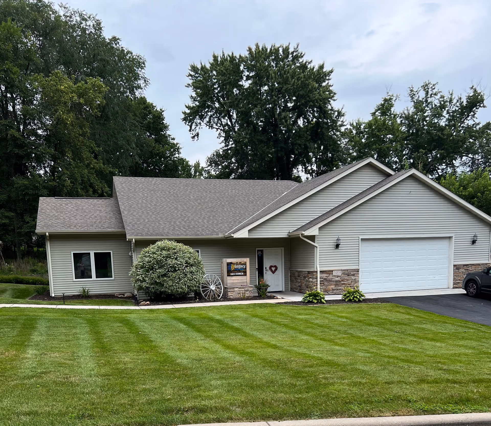 Front exterior of Legacy Care Home showing a single-story building with a manicured lawn.