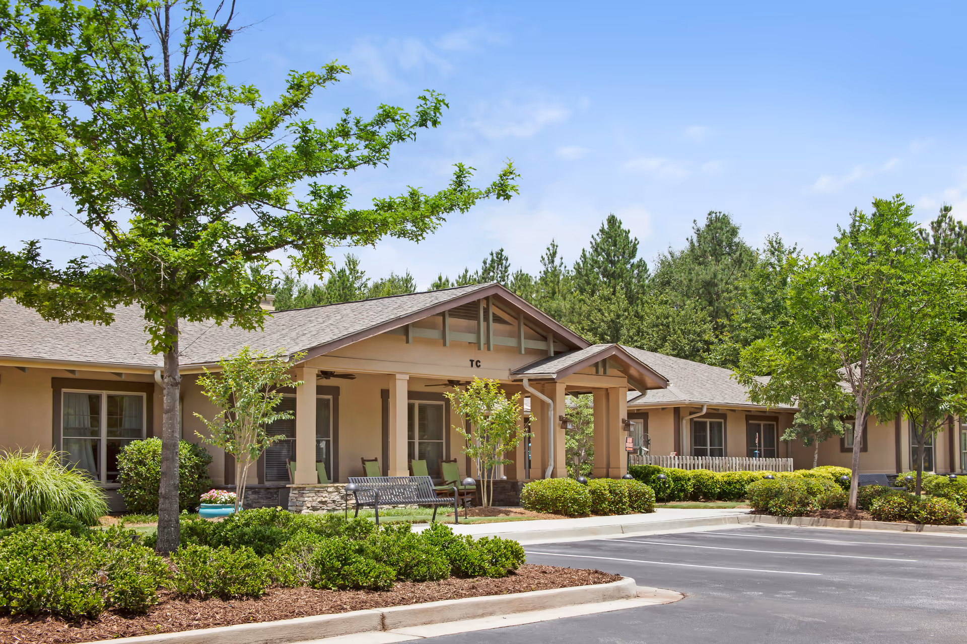 Single-story Sunrise at Webb Gin facility exterior with entryway, benches, and landscaped parking lot.