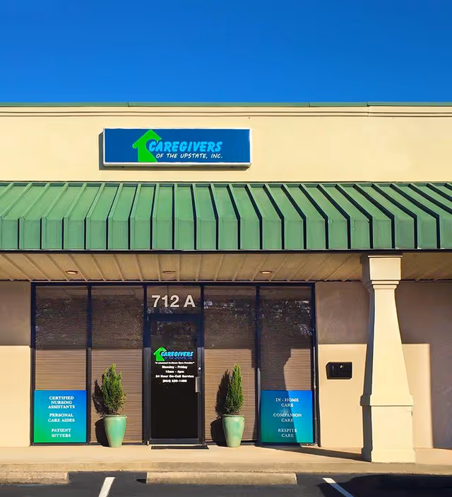 Exterior view of Caregivers of the Upstate storefront with a green awning and plants.