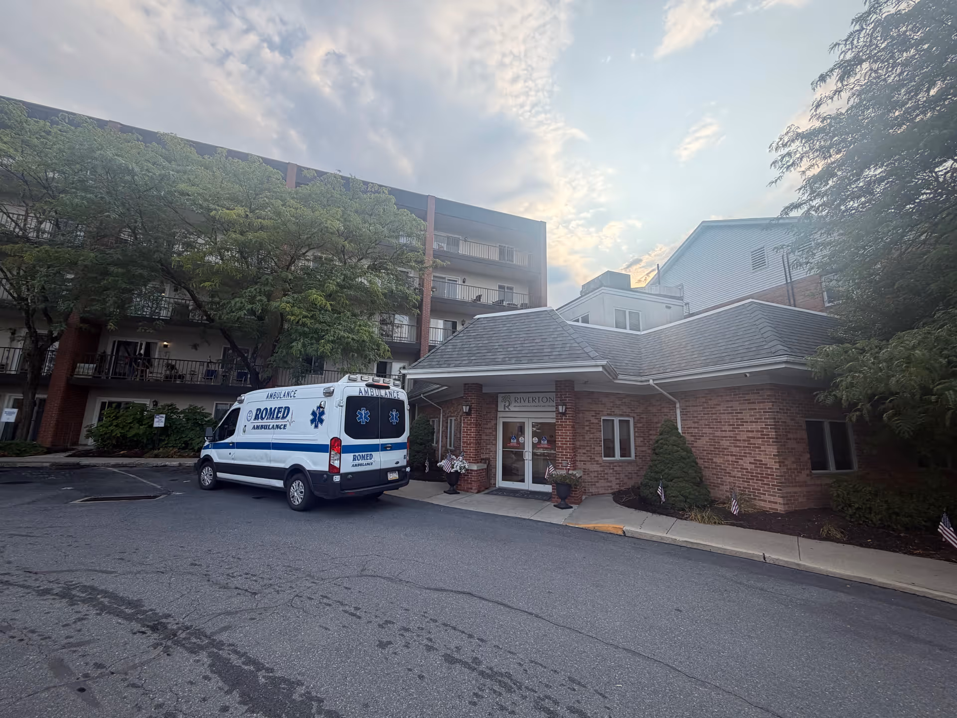 Front view of Riverton Enhanced Senior Living facility with an ambulance parked outside.