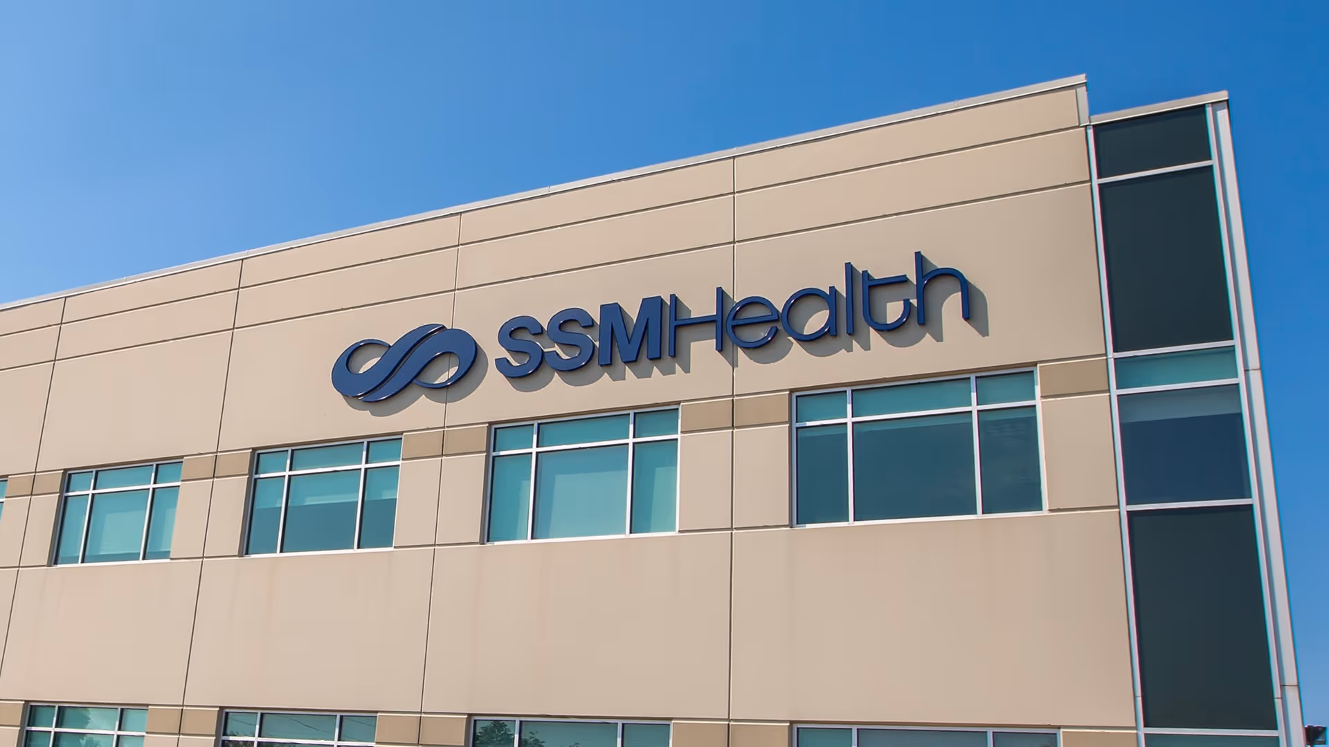 Exterior view of a beige SSM Health building with blue logo and windows.