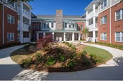 Exterior view of Thomas Dd Site 1 senior living building with circular landscaped island