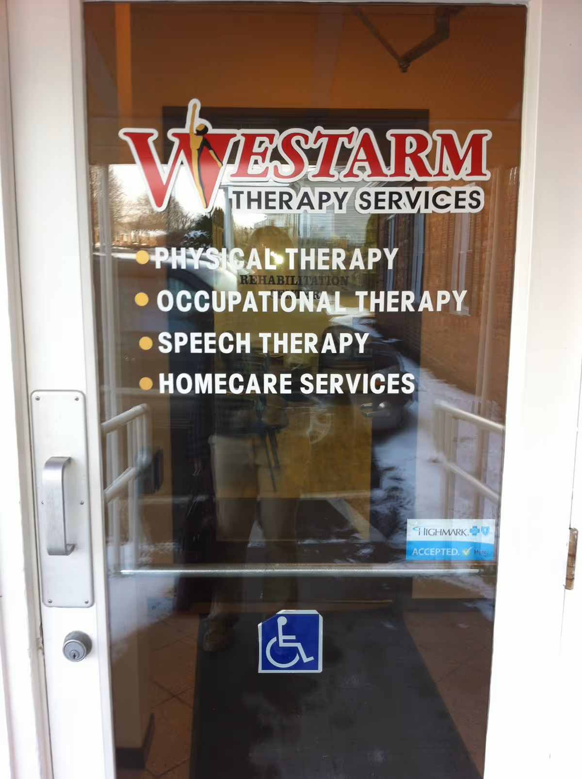Glass entrance door displaying Westarm Therapy Services logo and listed therapies.