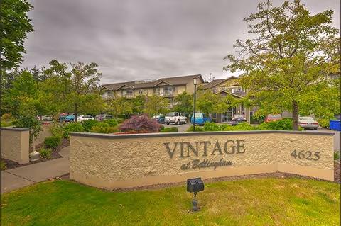 Exterior view of Vintage at Bellingham entrance with curved sign and landscaping