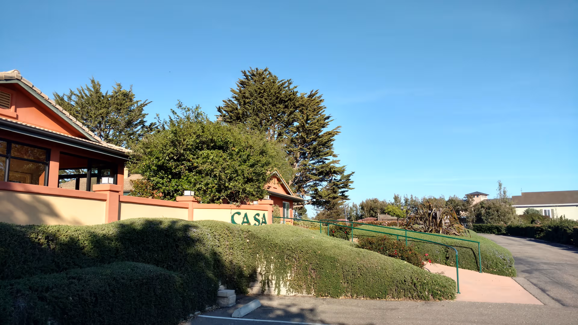 Exterior view of Casa Rosa Elder Care with landscaped entrance and sign.
