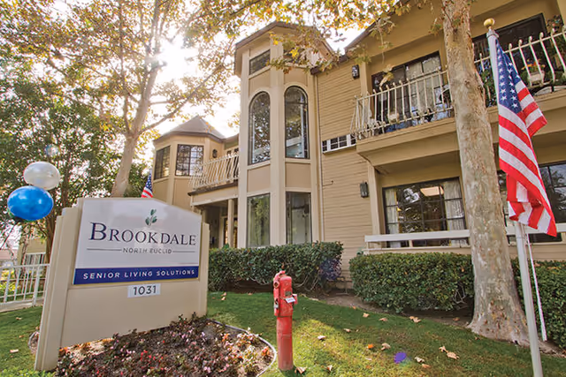 Exterior view of Brookdale North Euclid senior living building with sign and flags.