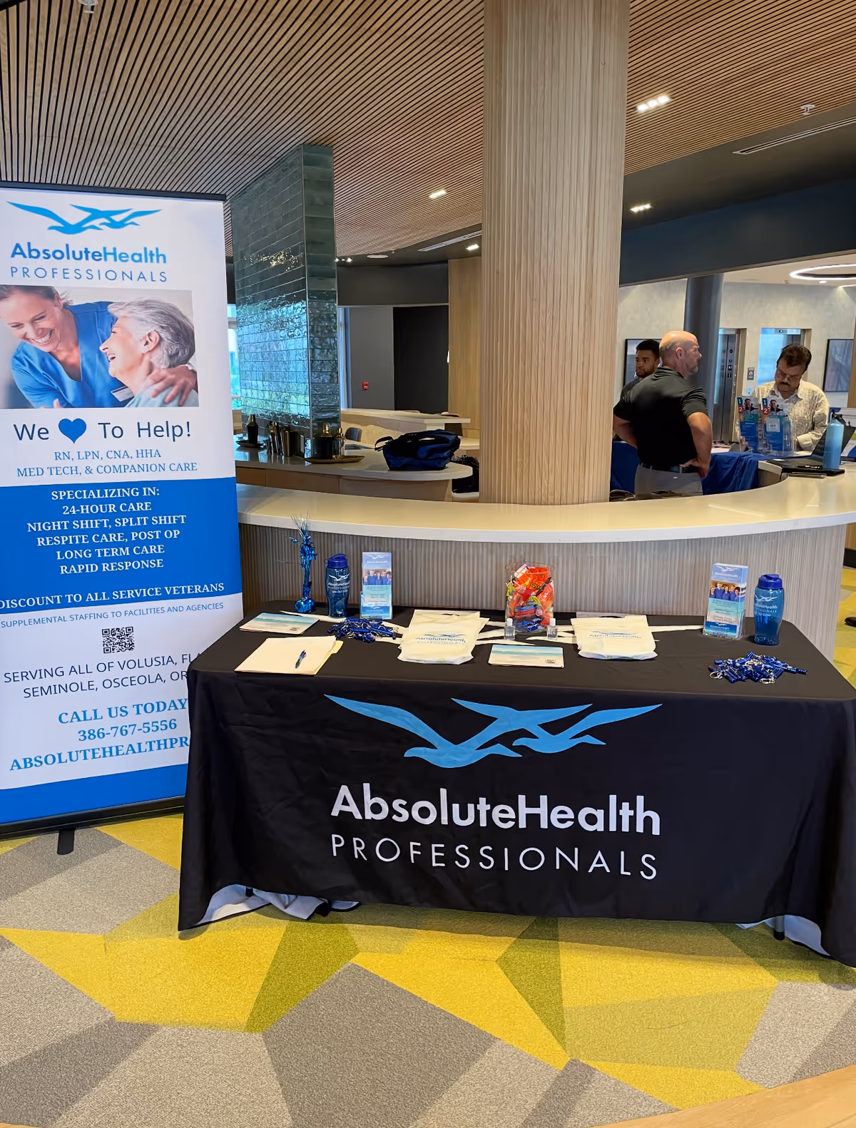 Interior reception area with a curved desk, banner, and table for AbsoluteHealth Professionals.