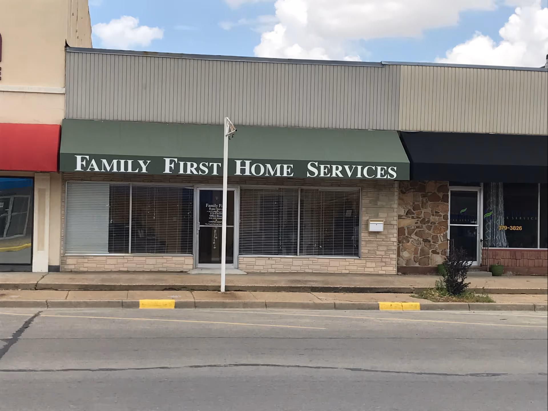 Exterior storefront with green awning displaying Family First Home Services.