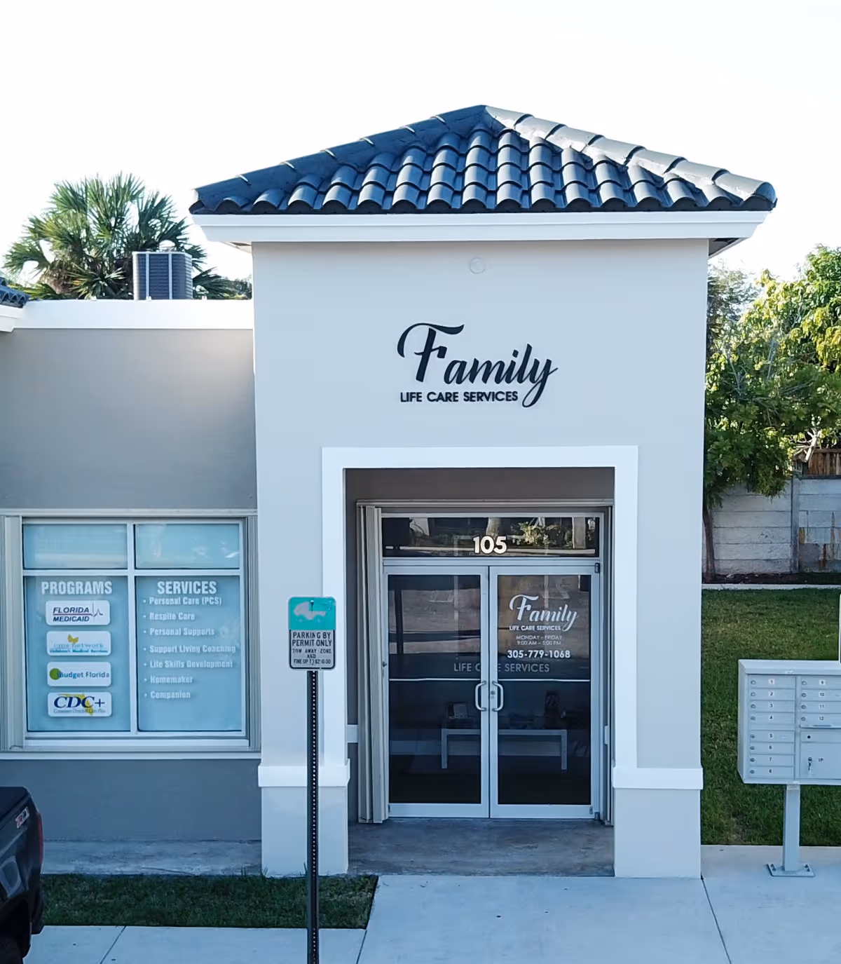 Front view of a white building with Family Life Care Services sign and glass entrance.