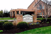 Brick building entrance with curved driveway and sign for Hillebrand Nursing & Rehabilitation Center.
