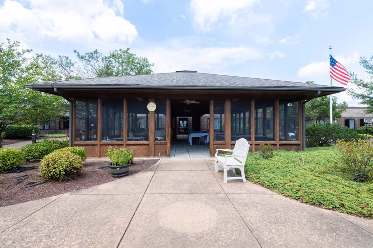 Front exterior view of RRH Demay Living Center with screened porch and flag