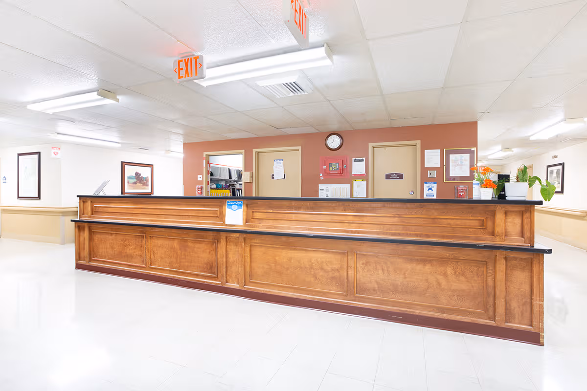 A long wooden reception desk in a bright Heritage Hall King George lobby.