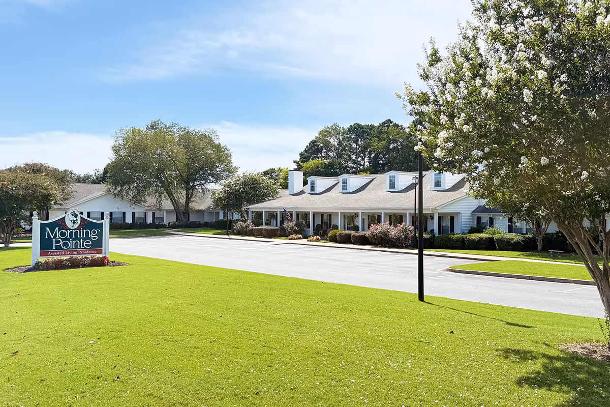 Exterior view of Morning Pointe of Calhoun with lawn, driveway, and front sign.