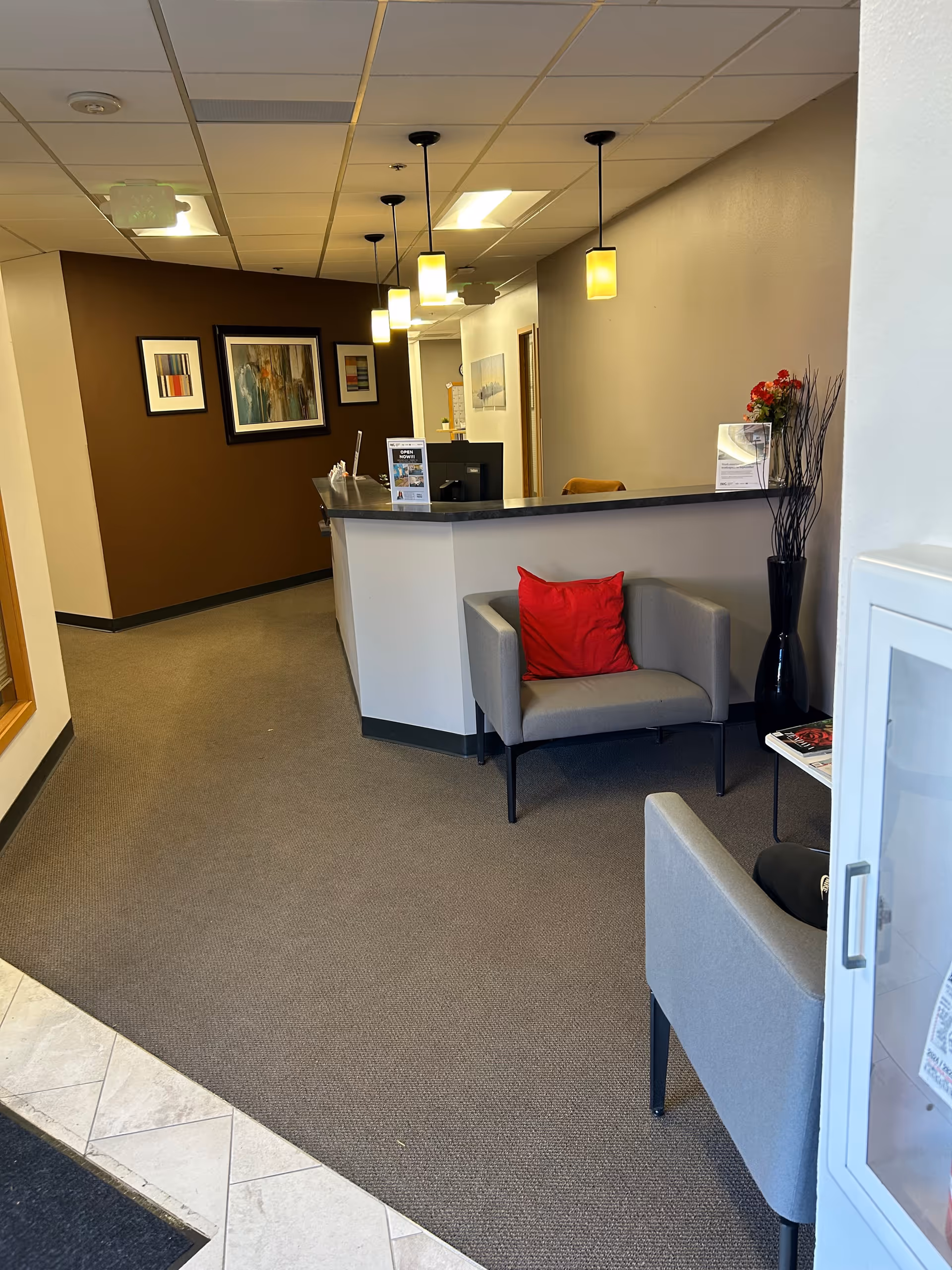 Modern senior living lobby with a reception desk, seating, and wall art.