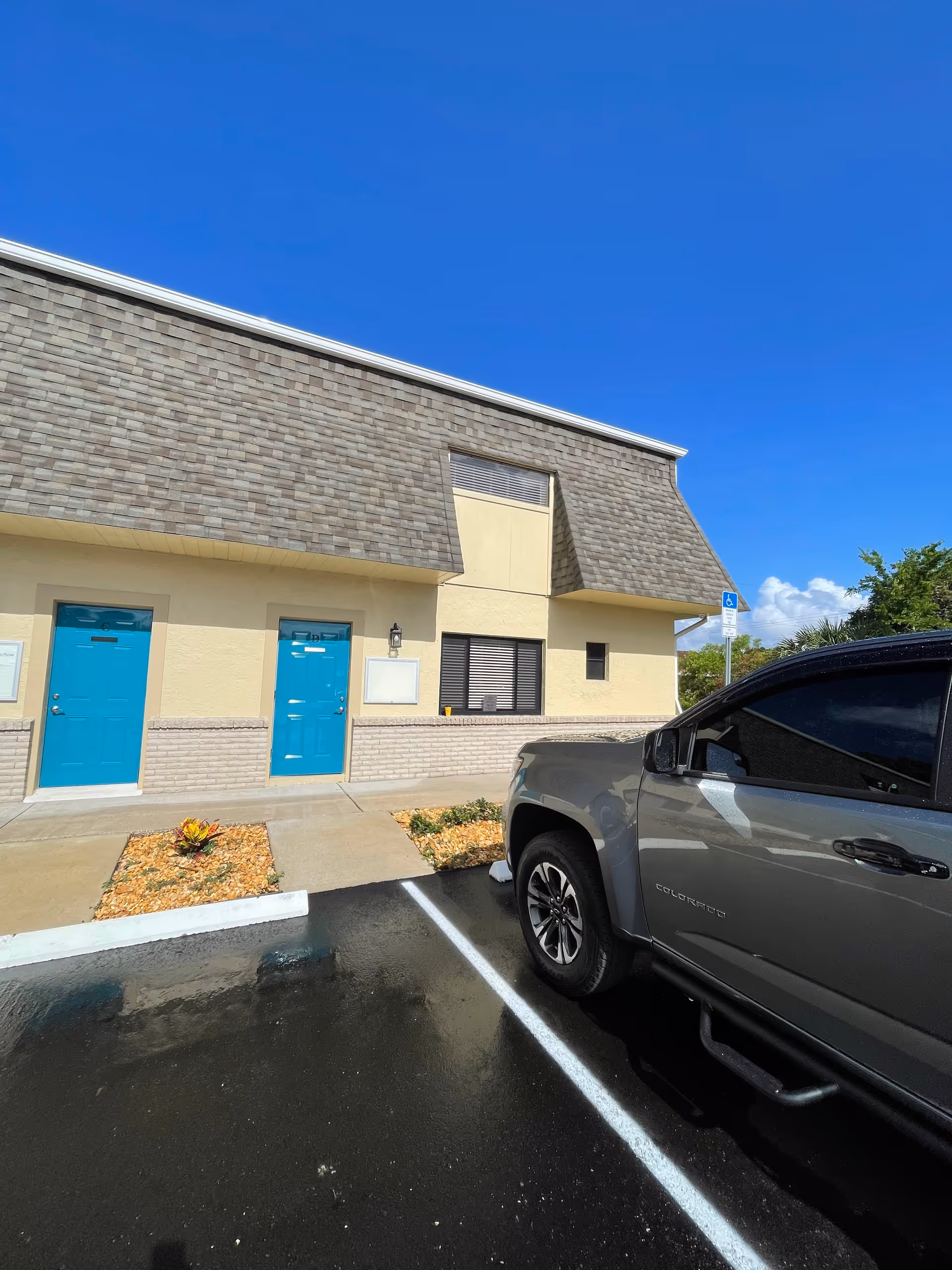 Exterior view of Angie’s Senior Care facility with blue doors and a parked truck.
