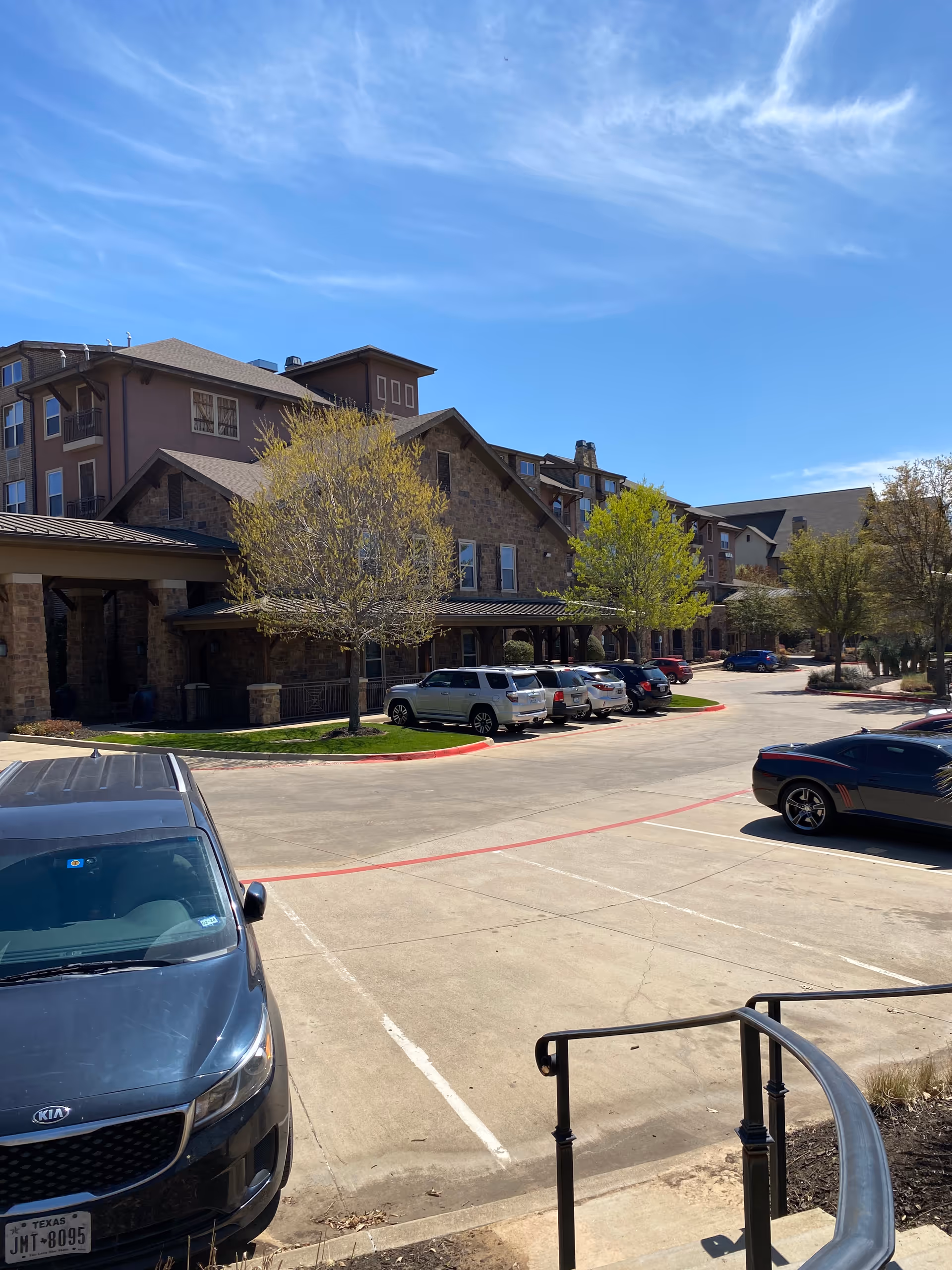 Exterior view of Discovery Village at Southlake with parked cars and trees.