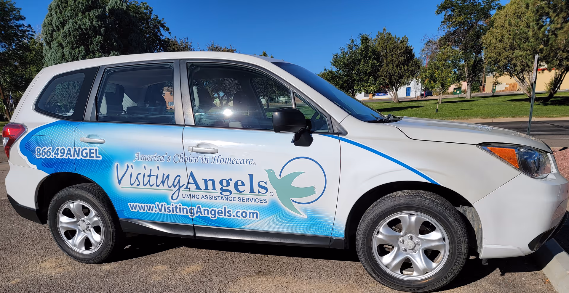 Branding on a white and blue Visiting Angels van parked outdoors.