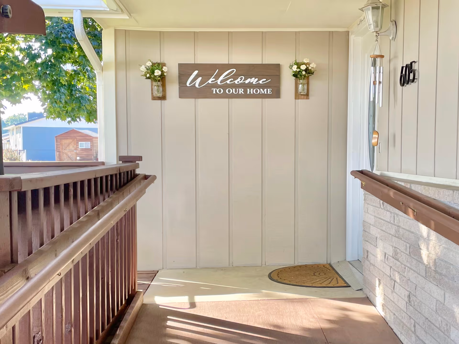 Front entry porch of Graceful Hearts Adult Family Home with welcome sign and railings.