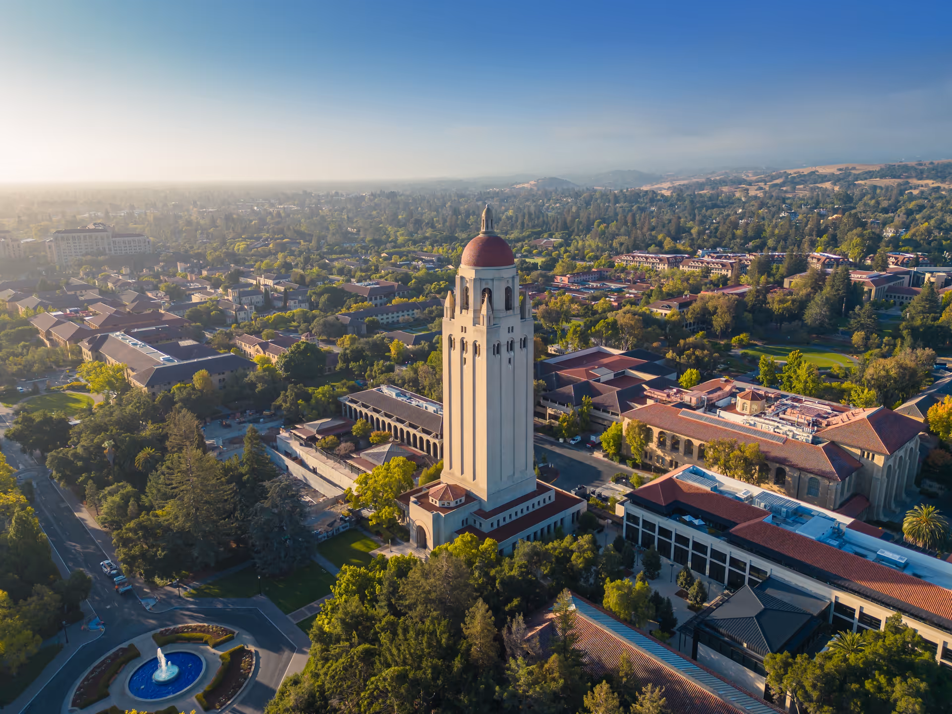 Aerial view of a campus with a tall central bell tower and surrounding buildings