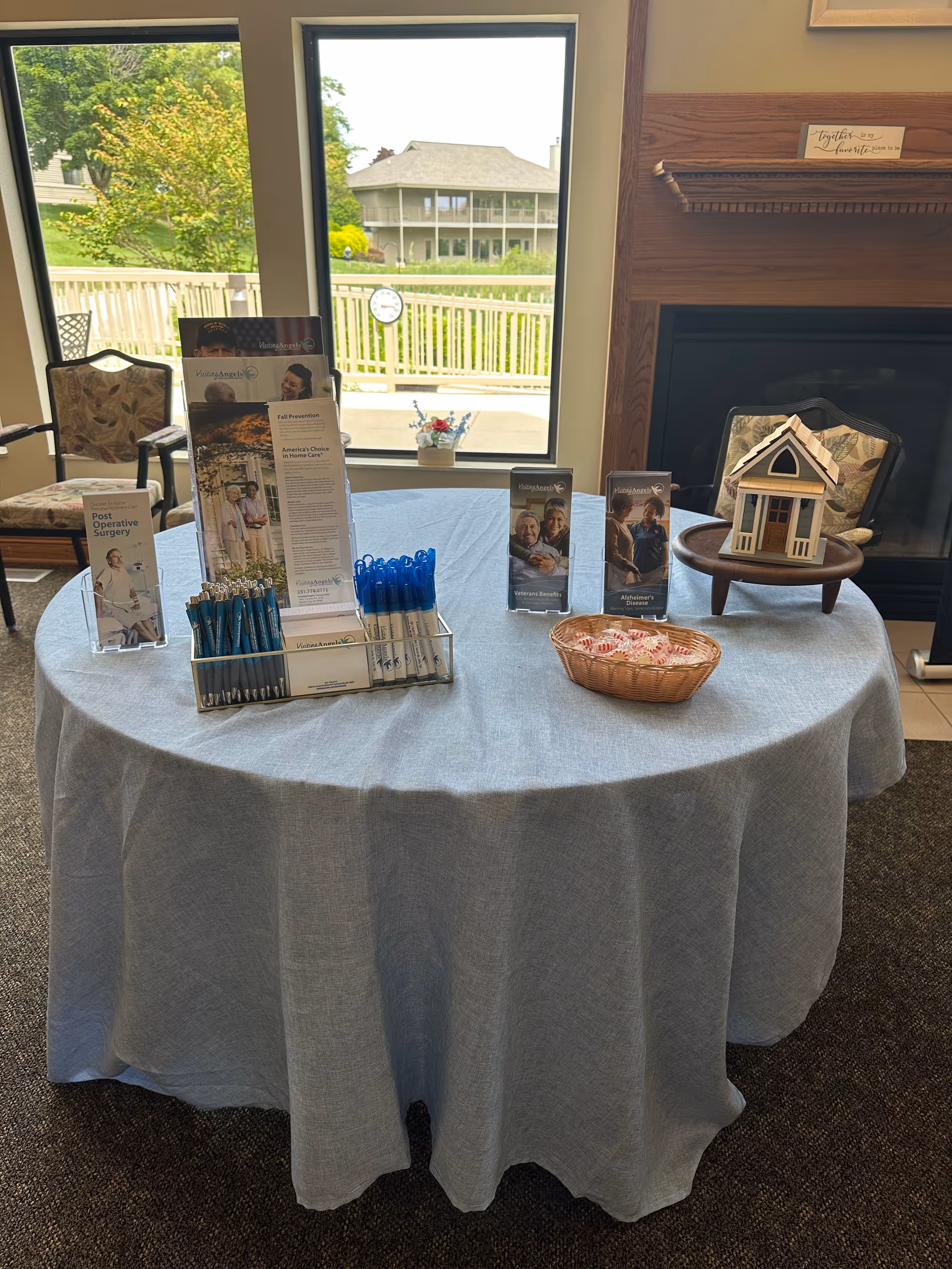 Round table with brochures and pens sits in a bright lobby area.