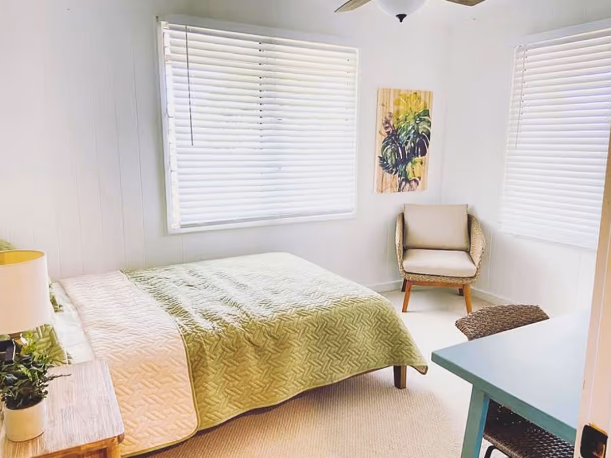 Cozy Valley Comfort Care Home bedroom with bed, chair, desk, and window blinds.