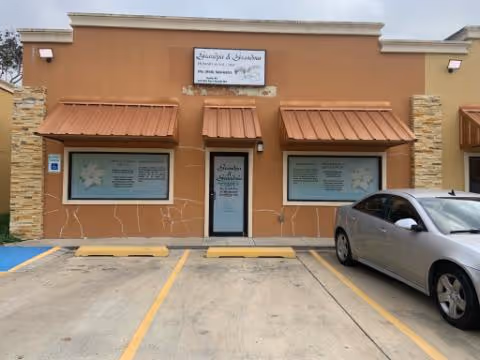 Exterior of Grandpa & Grandma Primary Home Care building with orange facade and parking lot