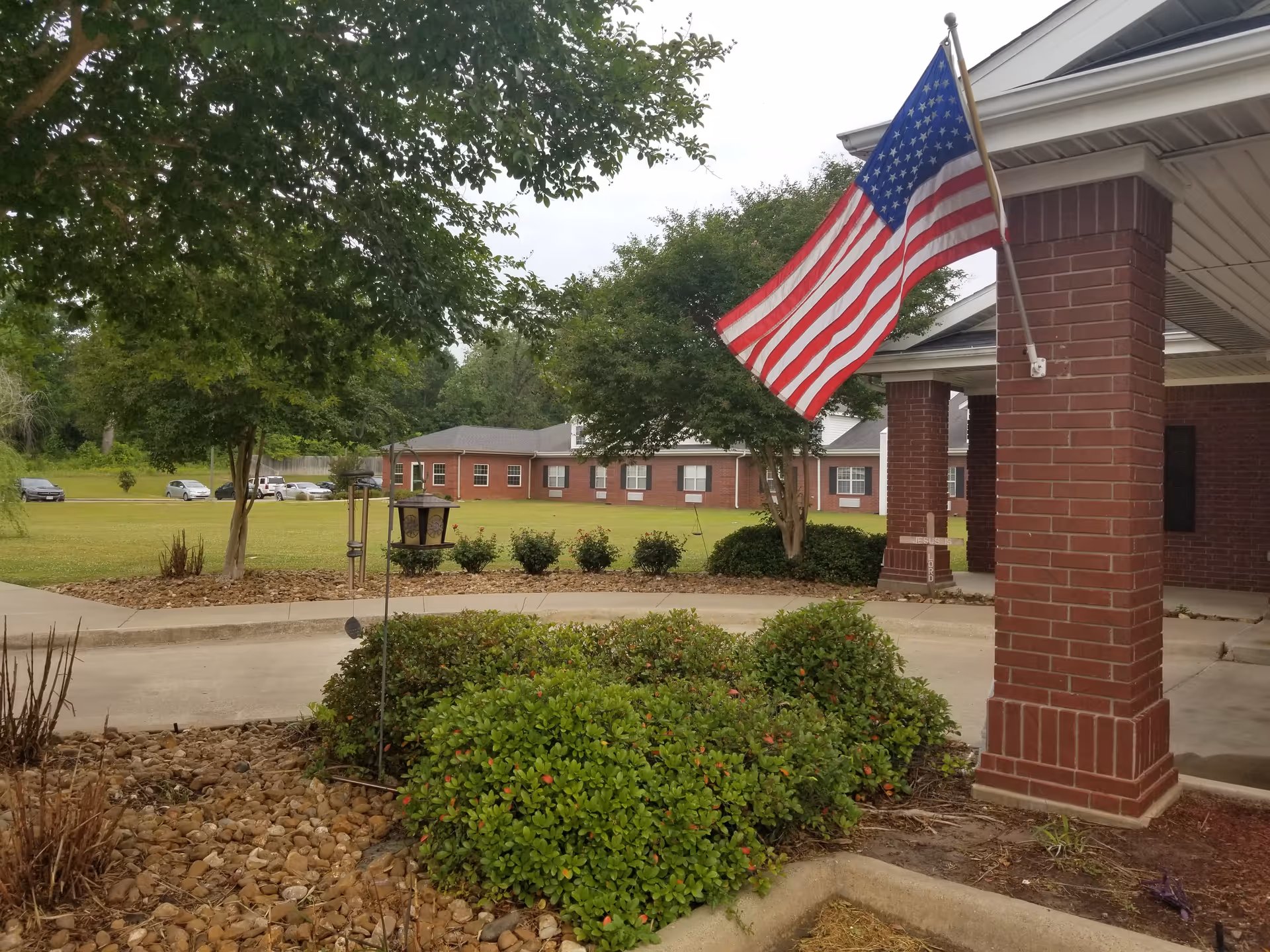 Exterior view of Castle Pines Health and Rehabilitation entrance with brick columns and American flag.