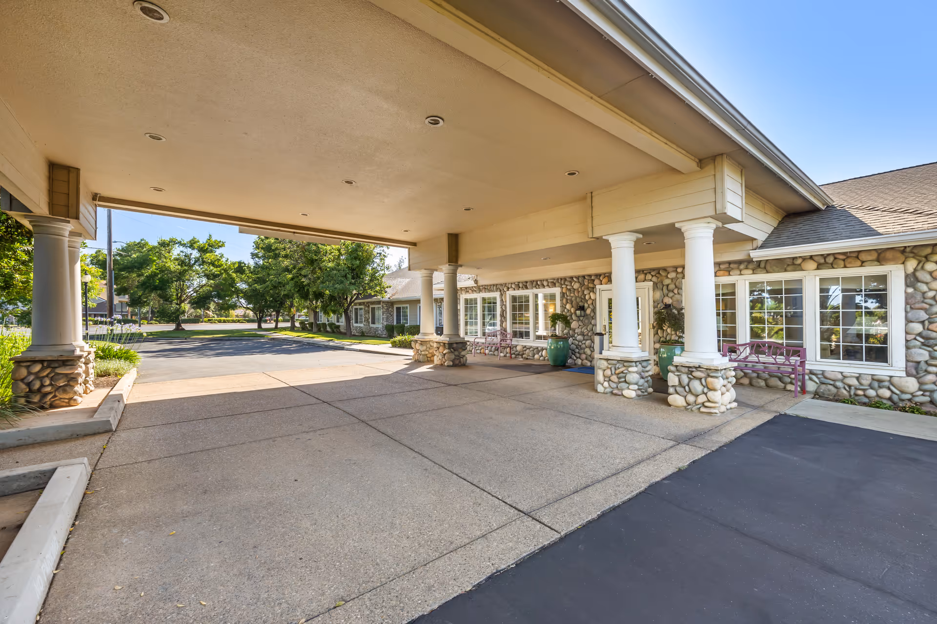Covered entrance with stone columns and large windows at Brookdale Lodi exterior.