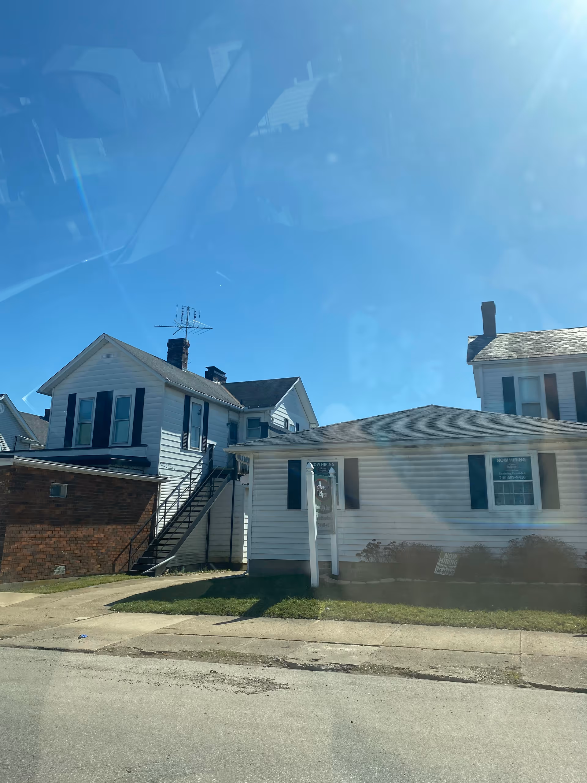 Sunny street view of residential building fronts on a clear day.