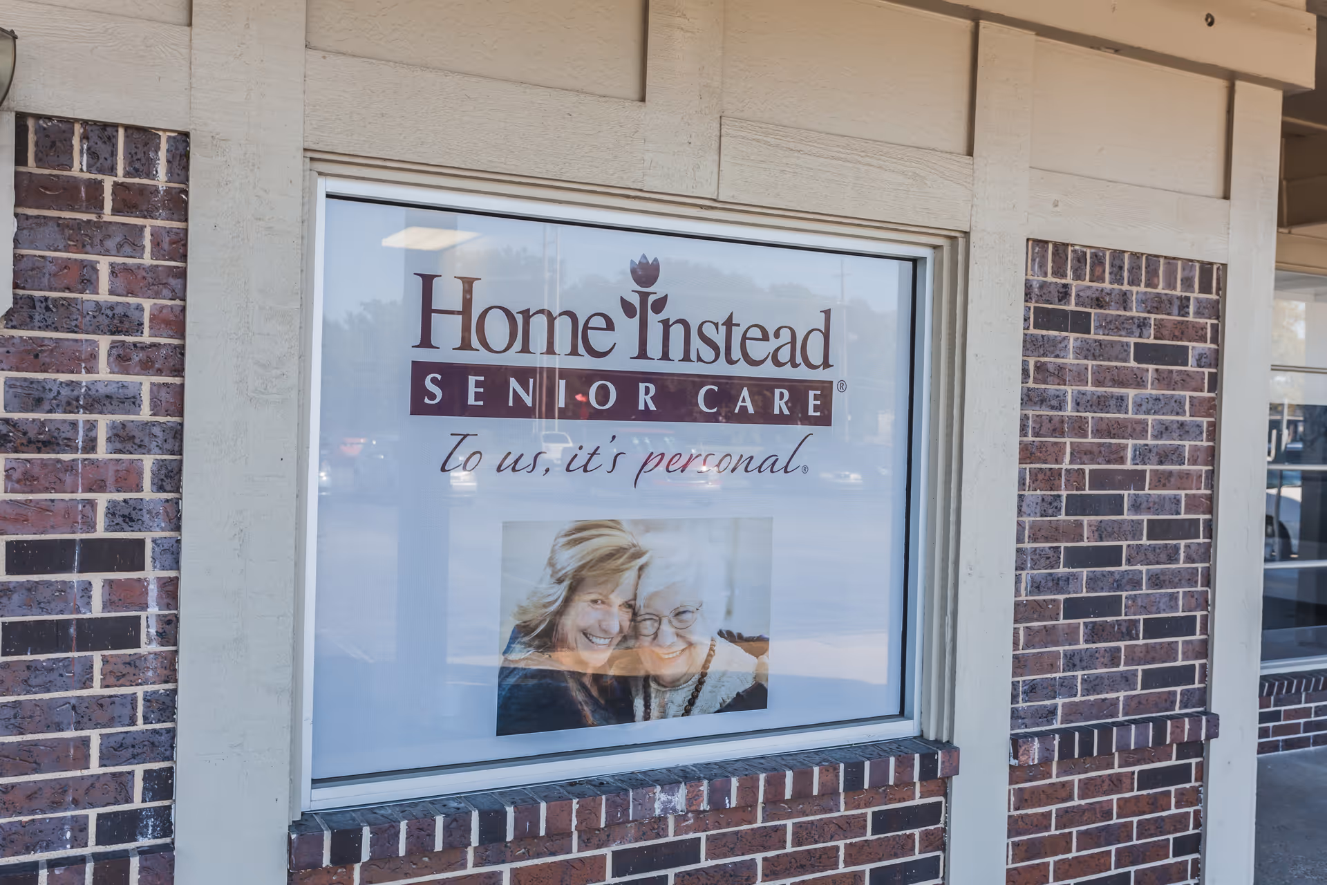 Brick building exterior featuring a window sign for Home Instead Senior Care