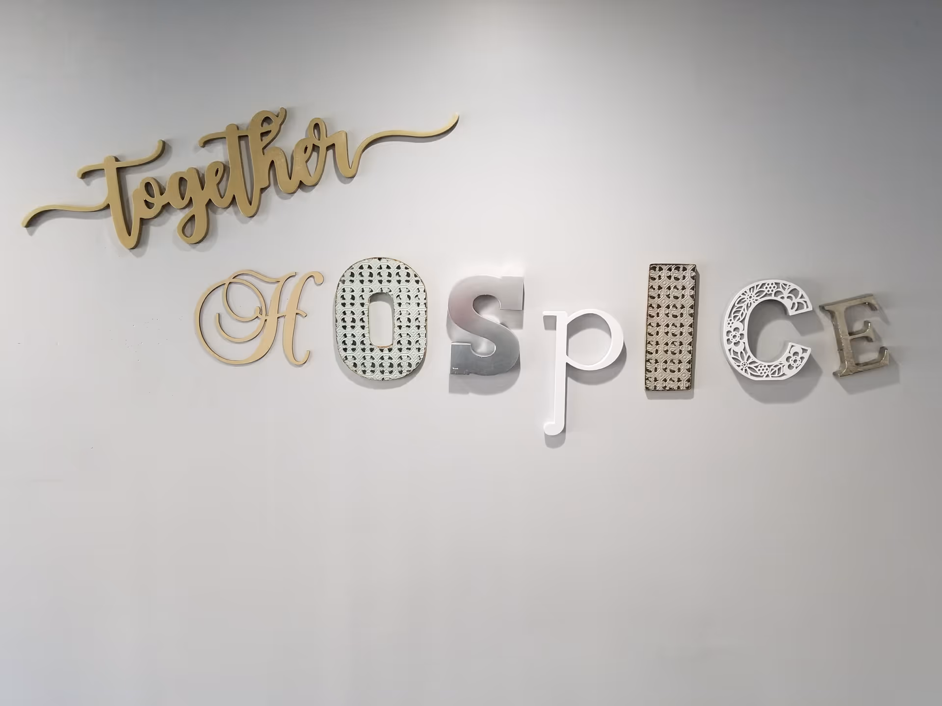 Decorative 'Together Hospice' sign mounted on a plain interior wall