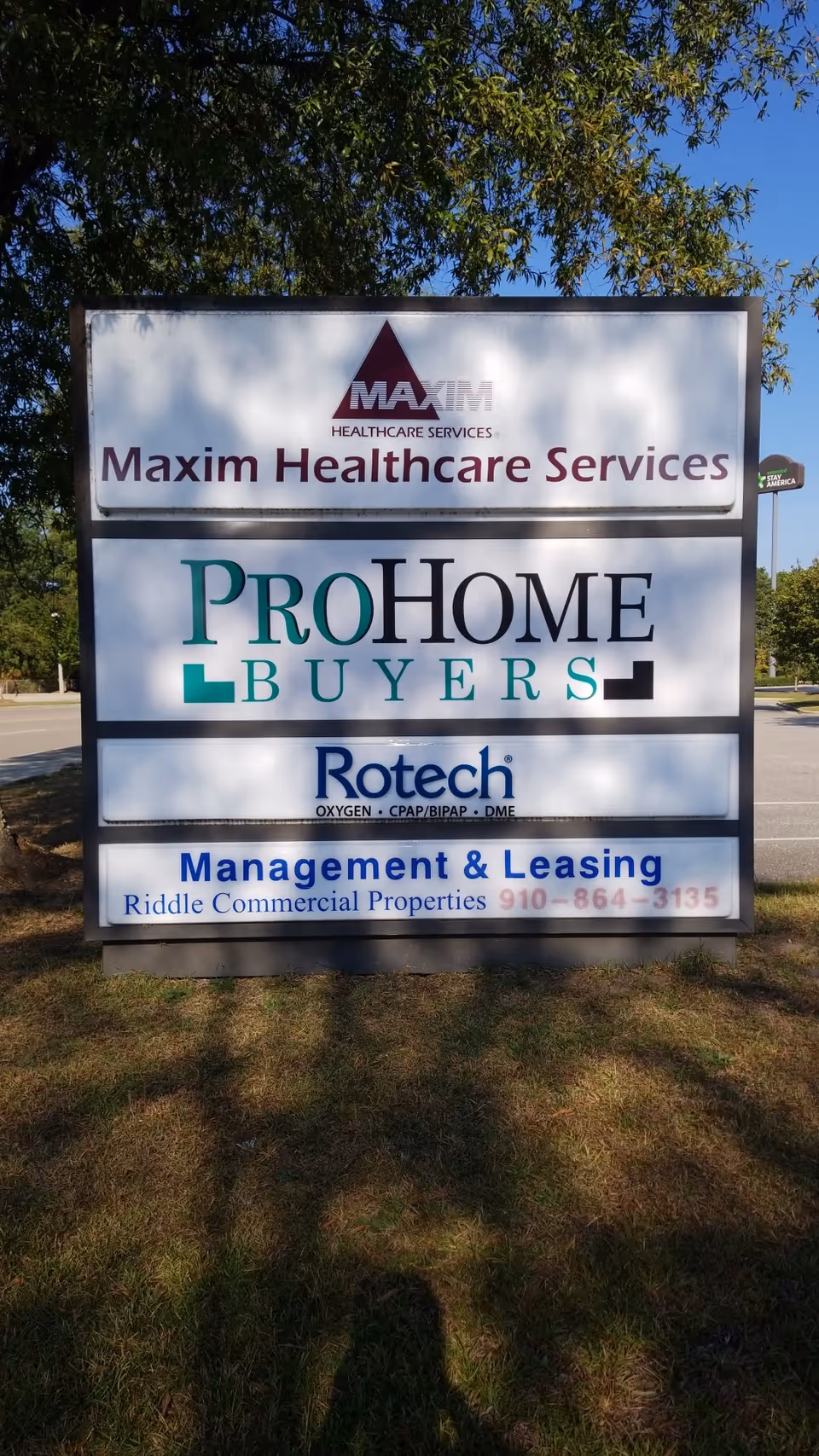 Outdoor sign displaying Maxim Healthcare Services Fayetteville and other business logos.
