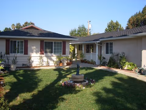 Single-story senior care home exterior with a courtyard fountain.