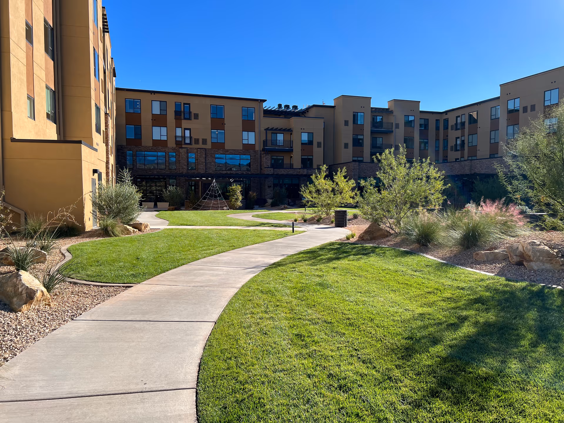 Exterior view of Atlas Homecare and Hospice of Southern Utah courtyard with buildings, lawn, and paths.