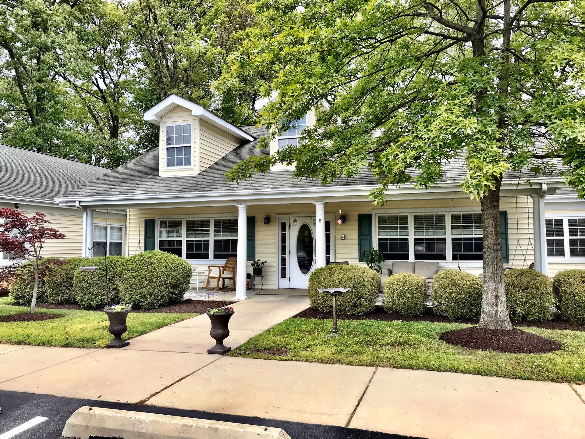 Exterior of Heart Homes Residence Bay Ridge II featuring a front porch and neatly trimmed shrubs.