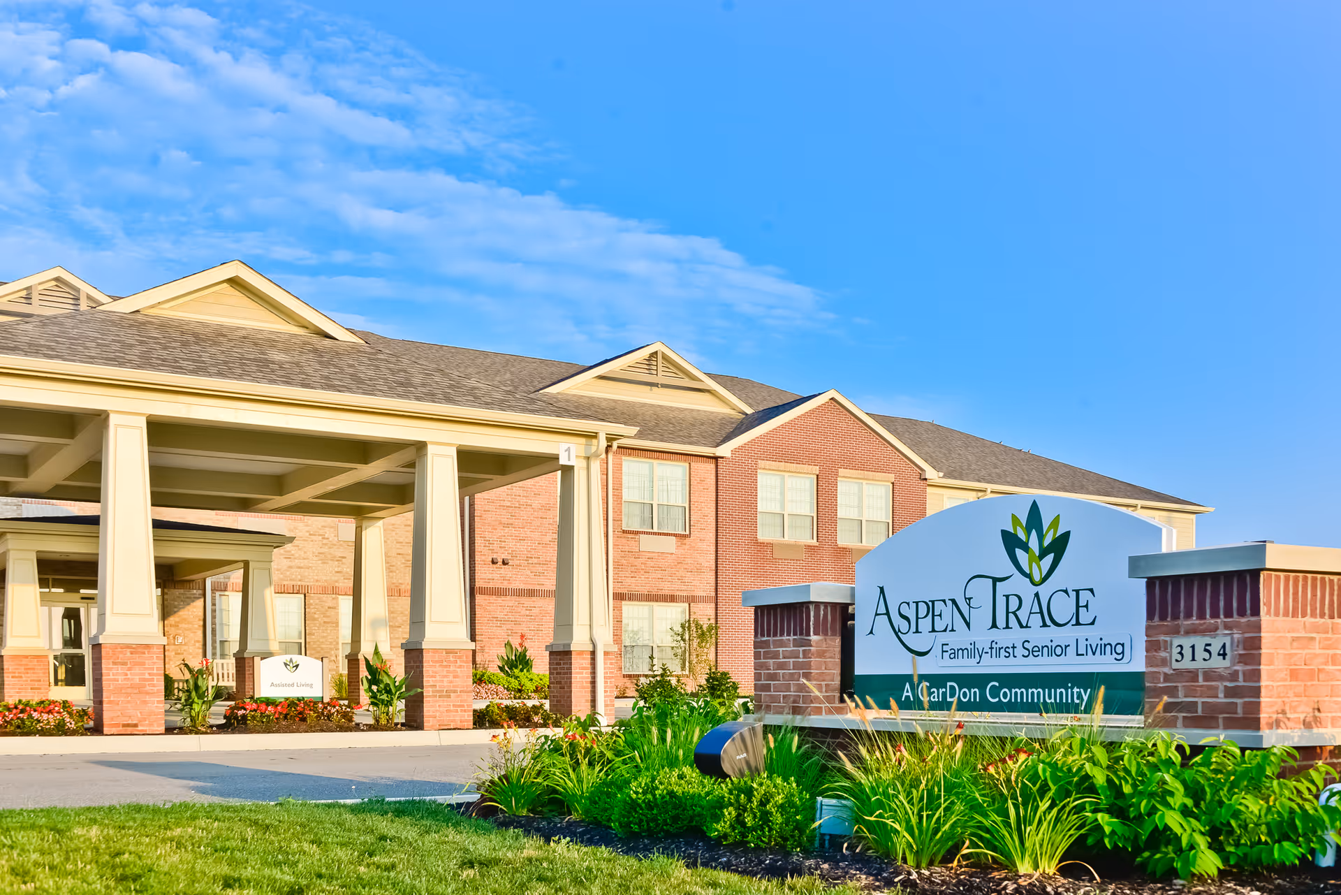 Exterior view of a brick senior living facility with Aspen Trace sign.