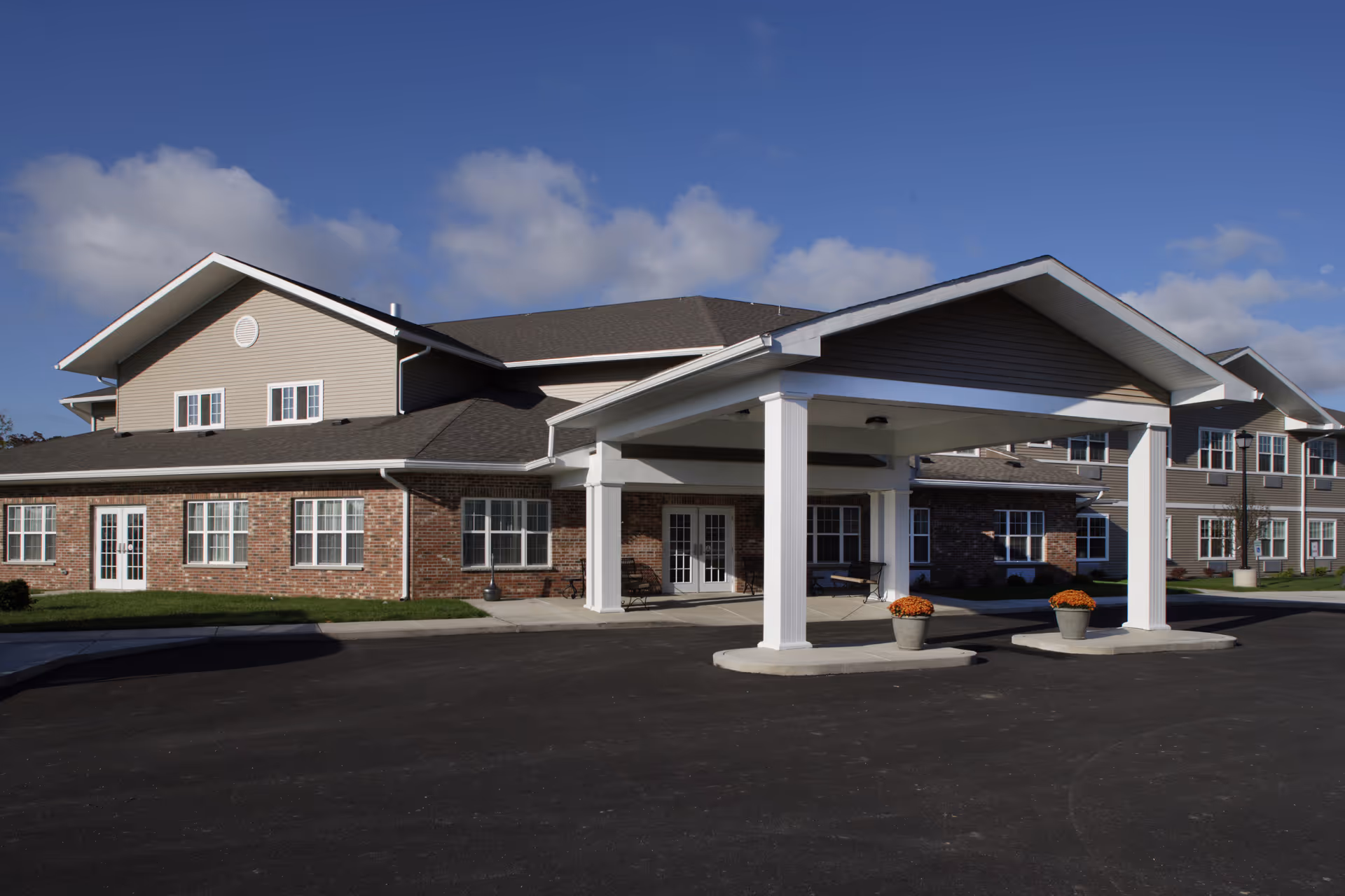 Exterior view of Elderwood Residences at Wheatfield with a covered entrance and brick facade.