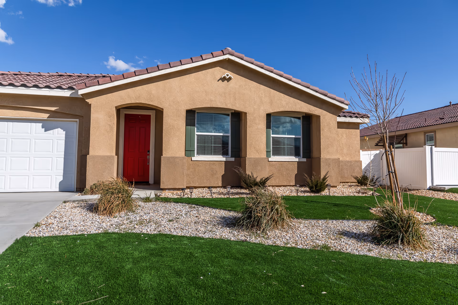 Single-story tan facility with a red front door and desert landscaping.